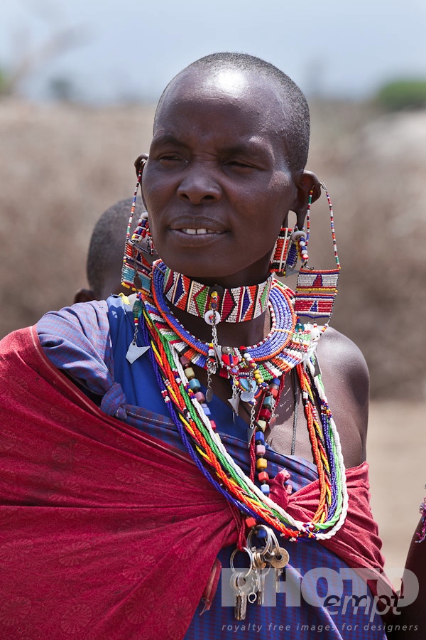 African Safari - Kenya. . . . . Closeup of young Masai woman in bright red sarong, and beaded jewellery, Masai village, Kenya, Africa