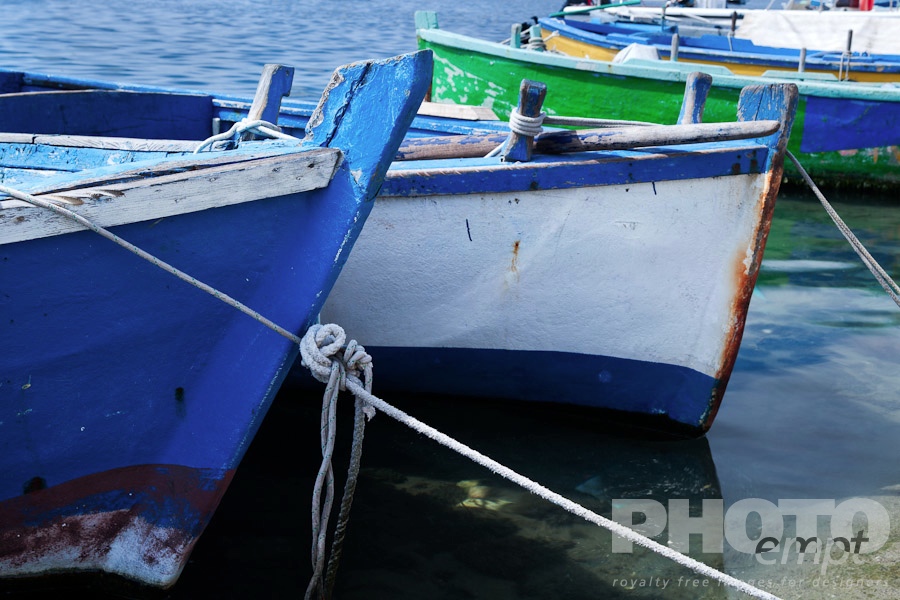 Italy South - Puglia. . . . . Close up view: prows of wooden painted blue and green fishing boats moored in Porto Cesareo harbour, sunny spring morning, Salento, Puglia, Southern Italy