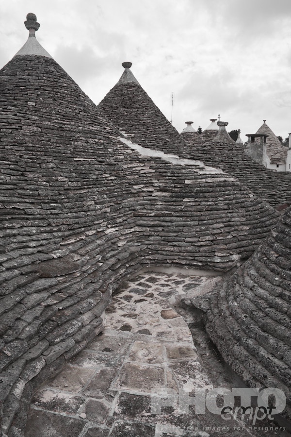 Italy South - Puglia. . . . . Rooftop view: town of Alberobello, World Heritage site, with trullo houses, white painted stone with piled stone conical roofs and large chimneys,  monochrome view,  Puglia, Southern Italy
