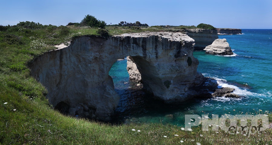 Italy South - Puglia. . . . . Rocky coastline and natural arch formation of sea stacks , clear blue sea on sunny spring morning, Salento, Puglia, Southern Italy