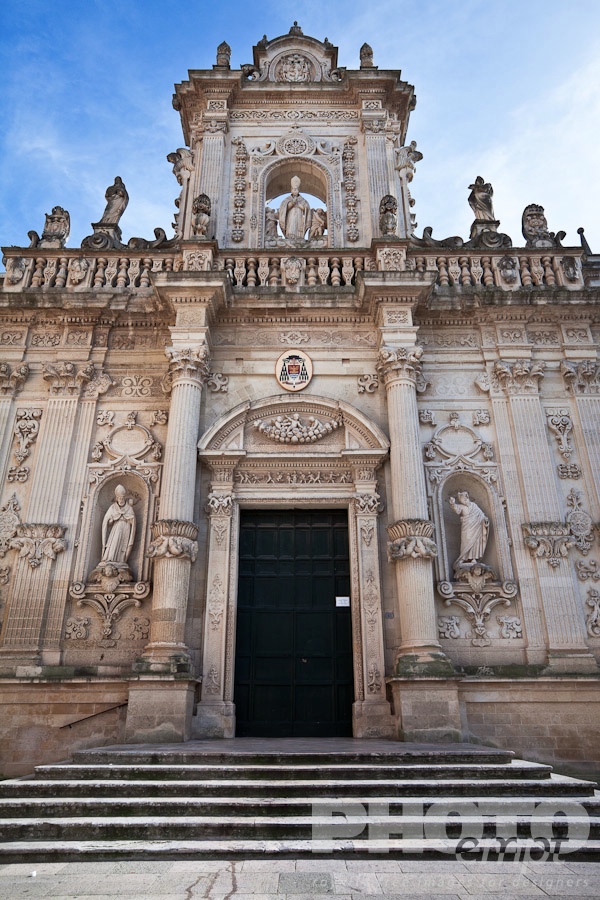 Italy South - Puglia. . . . . Facade of Duomo (cathedral), exuberant Baroque ornamentation of facade, steps to doorway, sunny spring morning with blue sky, Lecce, Salento, Puglia, Southern Italy
