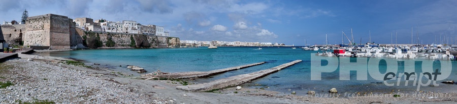 Italy South - Puglia. . . . . Panorama view of Otranto harbour with moored sailboats and motorboats, medieval fortifications and town, sunny spring morning with blue sky, Salento, Puglia, Southern Italy