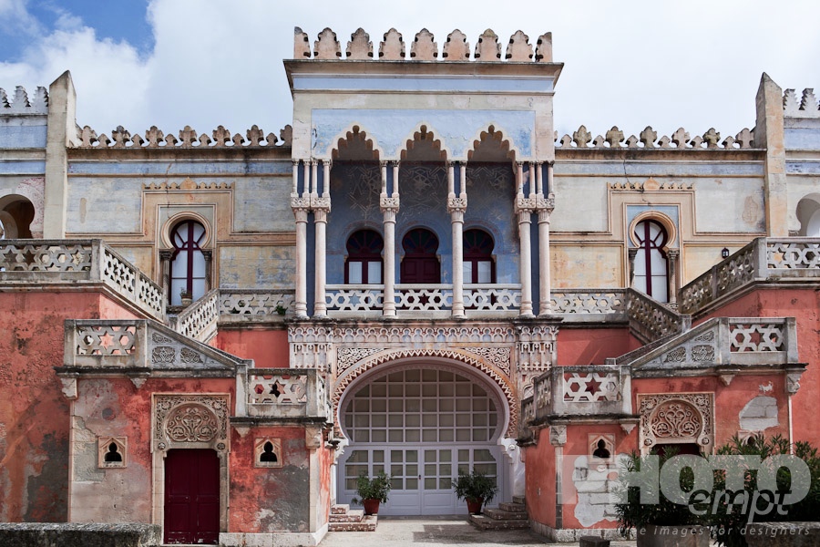 Italy South - Puglia. . . . . Frontal view : facade of colourful Moorish style 19th century Villa Sticchi, with stucco painted blue, orange and pink, against sunny blue sky, Santa Cesarea Terme,  Salento, Puglia, Southern Italy