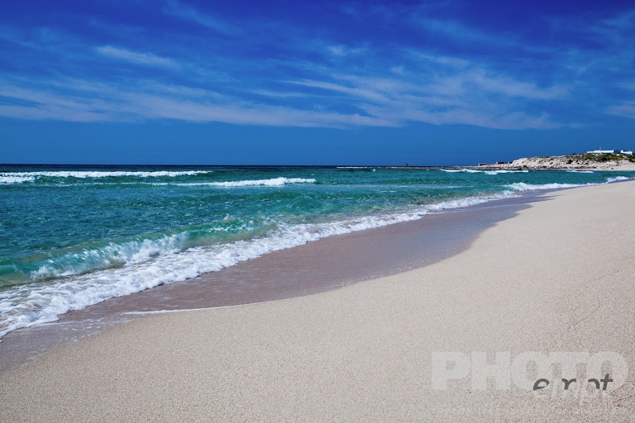 Italy South - Puglia. . . . . Sandy beach and rolling waves, clear green sea and blue sky, sunny spring morning, Salento, Puglia, Southern Italy