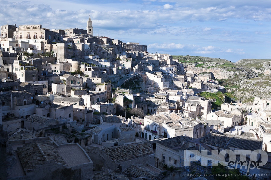 Italy South - Puglia. . . . . Aerial panorama of ancient town of Matera with tufa houses, Duomo Campanile on hill beyond, sunny spring afternoon with blue sky, Puglia, Southern Italy,