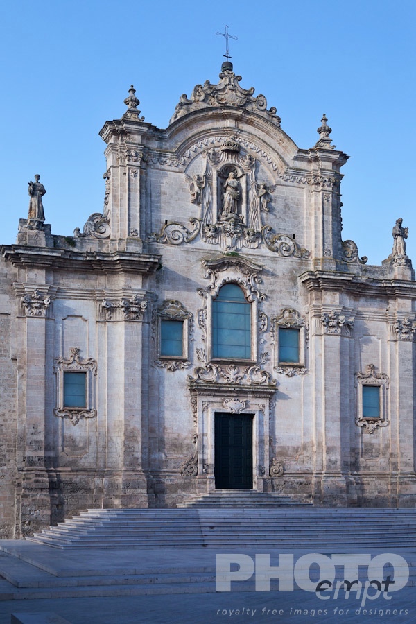Italy South - Puglia. . . . . View of piazza and stairs leading to Baroque facade of San Francesco, with typical stone carved scroll work and statues, decorated doorway, sunny spring evening, Matera, Puglia, Southern Italy