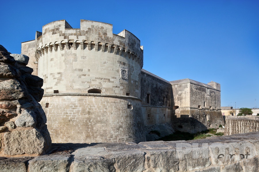 Italy South - Puglia. . . . . Typical defense castle of 16th century with rounded stone tower, outer wall and moat, Acaia, sunny spring afternoon, Salento, Puglia, Southern Italy
