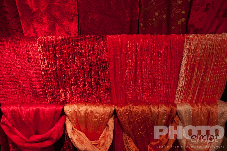 Venice in Autumn. . . . . Red velvet and silk scarves hanging in four rows, window display,  Venice, Northern Italy